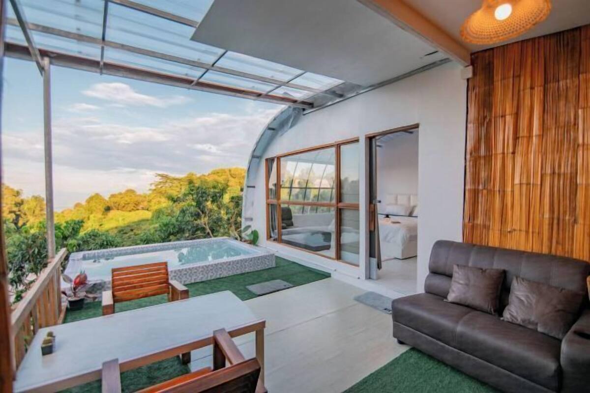 Un interior moderno con un patio de cristal, una piscina y una zona de estar.