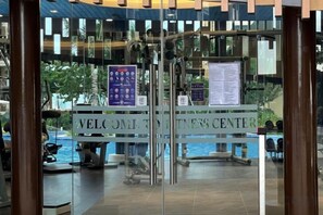 Entrada con puerta de vidrio a un hotel, con un cartel que dice 'WELCOME TO THE HOTEL CENTER'.