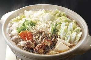 A bowl of hot soup with various vegetables and tofu. - Tsuzuya Village (Minokamo)