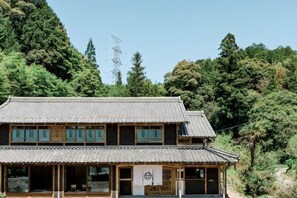 A traditional Japanese building with a tiled roof, wooden structure, and a small porch area.
