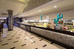 A buffet area with a marble countertop, various food items, and decorative cactus sculptures. - HRG Hurghada Aparthotel Aqua park A100 - By MAMO Property (Hurghada)