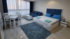 Una camera da letto moderna con un letto, comodini, una scrivania e sedie.