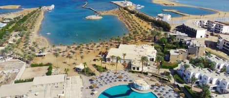 Un complexe hôtelier doté d’une piscine, d’une plage et offrant une vue sur l’océan.