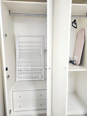 A white wardrobe with a hanging rack and a shelf.