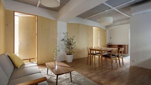 A spacious living area with a sofa, dining table, and chairs, wooden flooring, and a potted plant. - TokyoPan B&B (Tokyo)