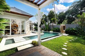 A modern house with a swimming pool, a patio, and a well-maintained garden. - Villa Anahata by BaliSuperHost (Bali)