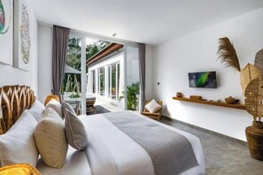 A modern bedroom with a large bed, a television, and a view of the outdoors. - Villa Anahata by BaliSuperHost (Bali)