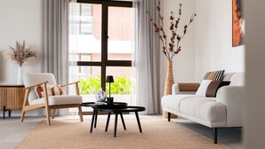 A modern living room with a sofa, armchair, and a coffee table. - Luxury apartment with terrace and views of Queen Emmabrug and Handelskade. (Willemstad)