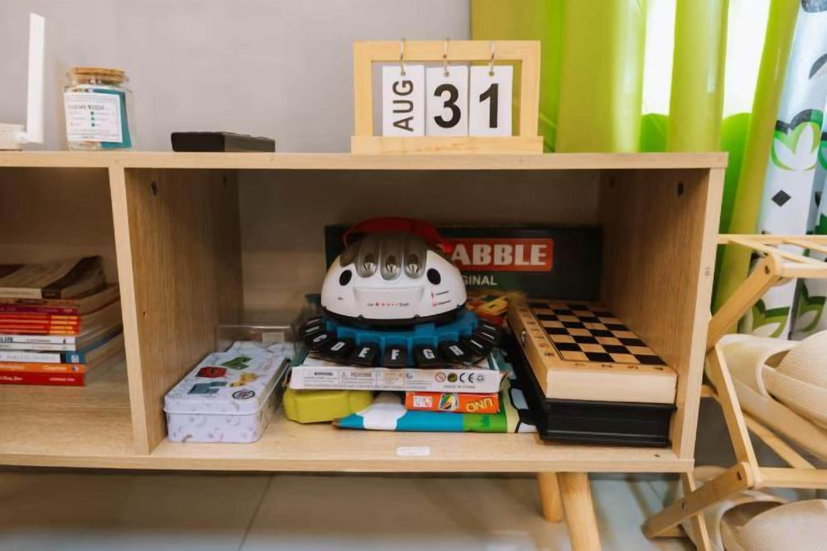 A shelf with a date sign, a plush toy, and various books.