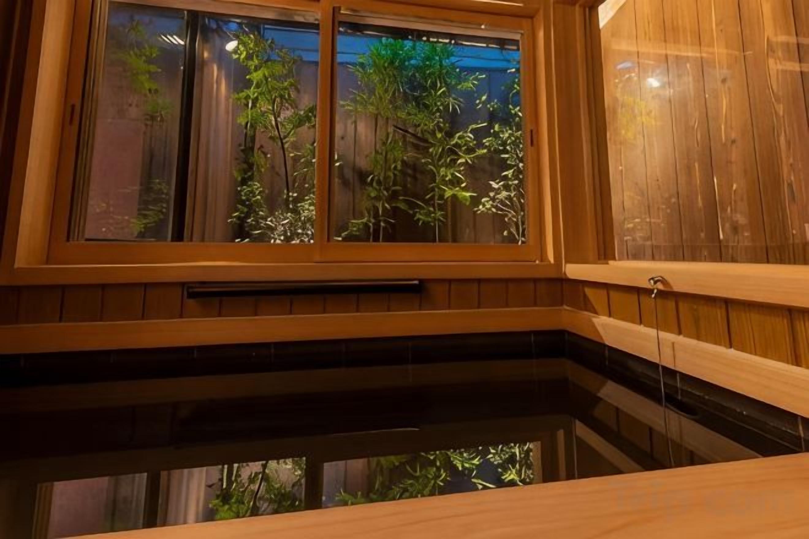 A wooden interior with a window overlooking a garden.
