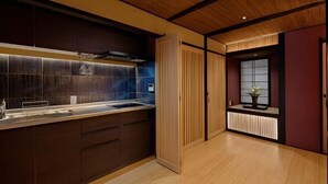 A modern kitchen with a wooden countertop, built-in cabinets, and a window with a view. - Kyoran Seigatei (Kyoto)