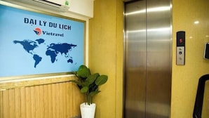 Un ascenseur dont les parois sont ornées d’une carte du monde et du logo de Viettravel.