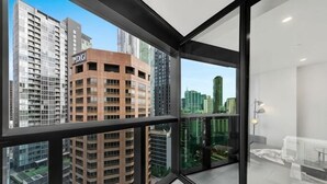 A modern apartment with large windows, a view of high-rise buildings, and a minimalist interior. - A Cozy Apt, Only a 5-min Walk to Victoria Market (Carlton)