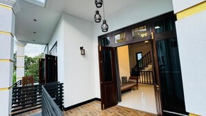 Un interior moderno con piso de madera, una escalera y vista a una habitación con escalera.