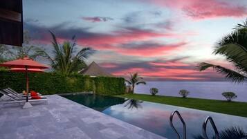 Una piscina con vistas al mar y al atardecer.