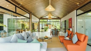 A spacious living area with a high ceiling, modern furniture, and large windows. - Baan Talay BeachFront Pool Villa B (Koh Samui)