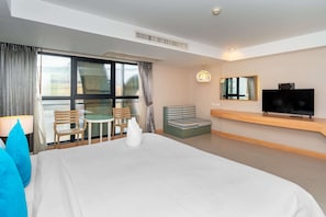 A hotel room with a large bed, a TV, a seating area with a table and chairs, and a balcony with a view. - Ratana Platinum Resort Kamala (Kamala)