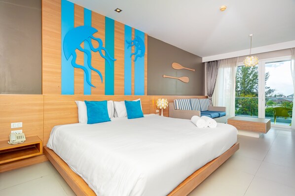 A modern hotel room with a large bed, a wooden headboard, a wall-mounted telephone, and a view of the outdoors. - Ratana Platinum Resort Kamala (Kamala)