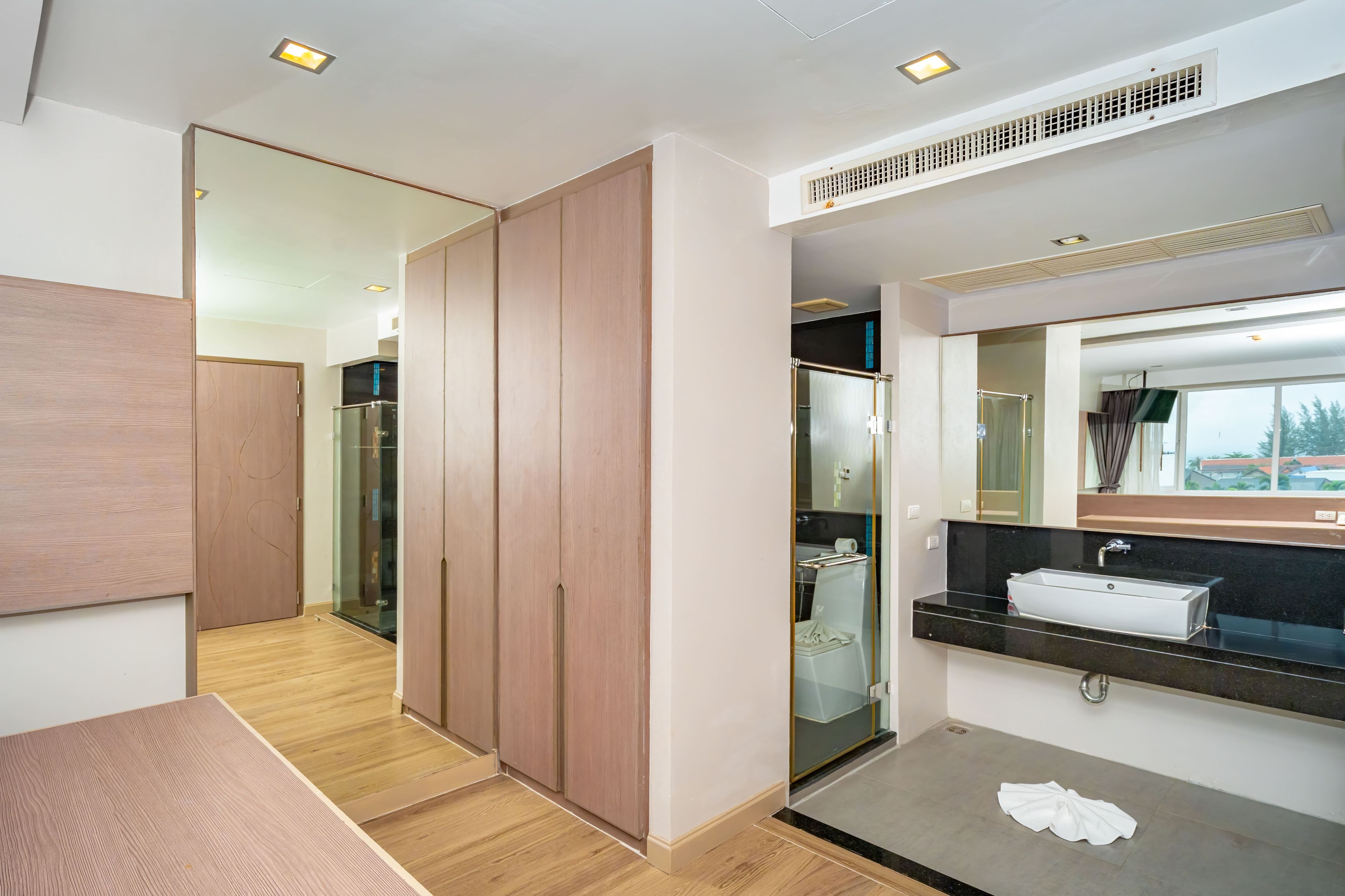 Un baño moderno con un espejo grande, un lavabo y una ducha a pie.