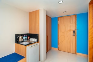 A compact kitchenette with a refrigerator, a coffee maker, and bottled water. - Ratana Platinum Resort Kamala (Kamala)