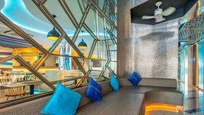 Een modern interieur met een zithoek, een plafondventilator en uitzicht op de eetruimte.