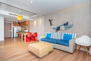Un salon moderne comprenant un canapé, une table basse et un coin repas avec des chaises et une table.