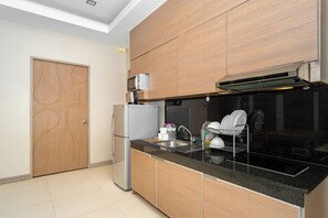 A modern kitchen with wooden cabinets, a built-in oven, and a stainless steel refrigerator. - Ratana Platinum Resort Kamala (Kamala)
