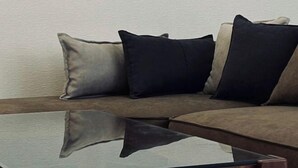 A sofa with a reflective glass table in front. - URBAN HOUSE KOENJI (Tokyo)