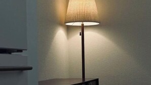 A modern lamp with a ribbed shade on a textured wall. - URBAN HOUSE KOENJI (Tokyo)