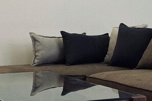 A sofa with three pillows in a neutral color scheme. - URBAN HOUSE KOENJI (Tokyo)