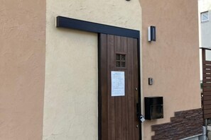 A door with a notice, a mailbox, and a small window. - URBAN HOUSE KOENJI (Tokyo)
