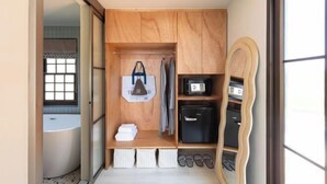 A compact bathroom with a bathtub, a wooden vanity with a mirror, and a towel rack. - Chunnchay Bed&Restaurant (Mae Wang)