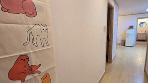 Een gang met een muur versierd met kattillustraties.
