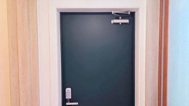 Een gesloten deur met een hendel en een slot.