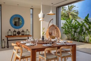A dining area with a wooden table set for six, surrounded by wicker chairs. - Sava Villa 6 Villa Roxo (Takua Thung)