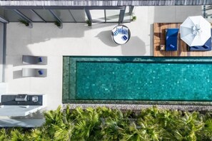 A rooftop pool with a view of the city, a lounge area with a table and chairs, and a small seating area with a table and chairs. - Sava Villa 6 Villa Roxo (Takua Thung)