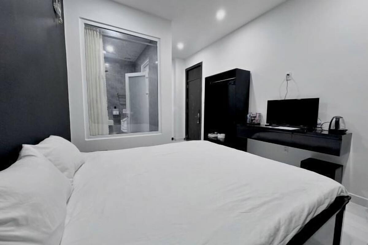A modern bedroom with a large bed, a TV, and a wardrobe.