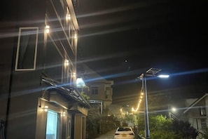 A nighttime street view with buildings, streetlights, and a parked car. - Chiu Home Da Lat (Dalat)