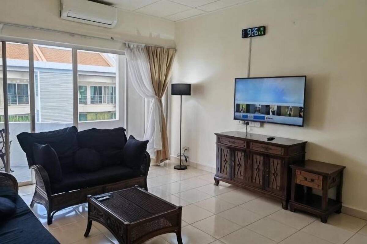 A living room with a sofa, coffee table, TV, and a cabinet.