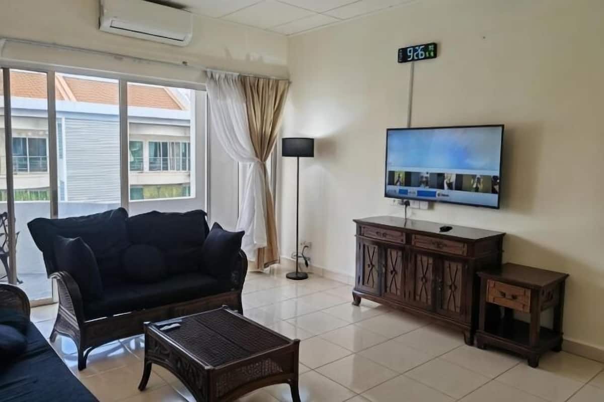 A living room with a sofa, coffee table, TV, and a cabinet.