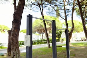 Ein Metallstab, aufgestellt in einem Park, mit einem daran befestigten Schild.