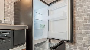 Une cuisine équipée d’un réfrigérateur encastré, d’un four à micro-ondes et d’un évier.