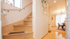 Un escalier avec des marches en bois et une rampe, menant à une pièce comprenant un coin repas.