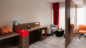 A modern hotel room with a wooden desk, a sofa, a TV, and a red curtain. - Zone by The Park New Market Kolkata (Kolkata)