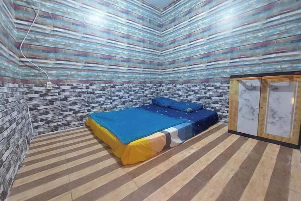 Una habitación con cama, armario y pared con diseño.