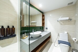 Un bagno moderno con doccia vetrata, lavandino bianco e water.