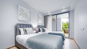 A modern bedroom with two beds, a balcony, and a large window. - Beachside 2BR 200 m to BangTao beach (Choeng Thale)