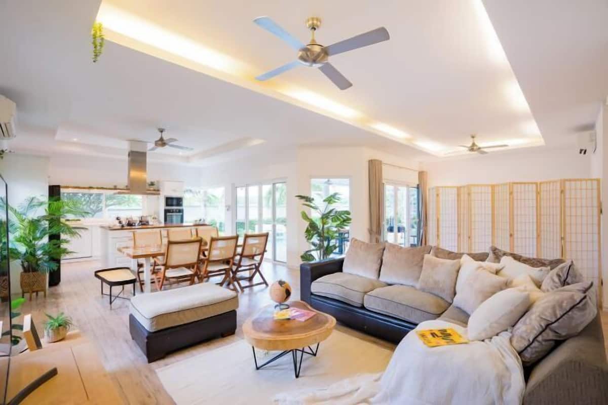A modern living room with a sofa, coffee table, and dining area.
