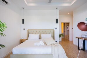 Un dormitorio moderno con una cama grande, mesitas de noche, un armario y un escritorio con una silla.