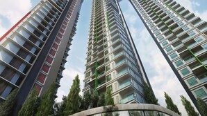 Deux immeubles résidentiels de grande hauteur, dotés de balcons et entourés de verdure.